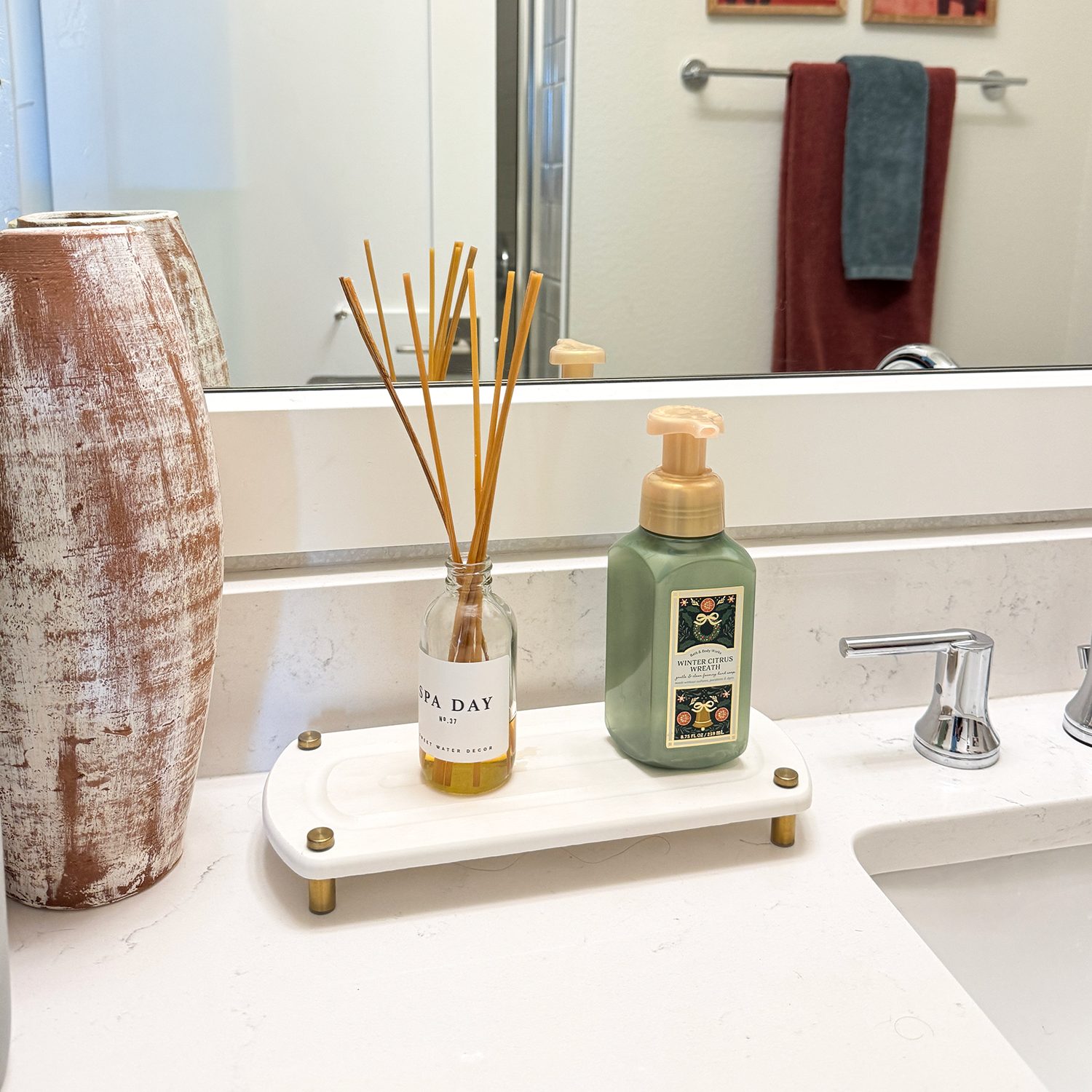 diffuser and hand soap on glacier gray sink caddy next to plant and bathroom decor