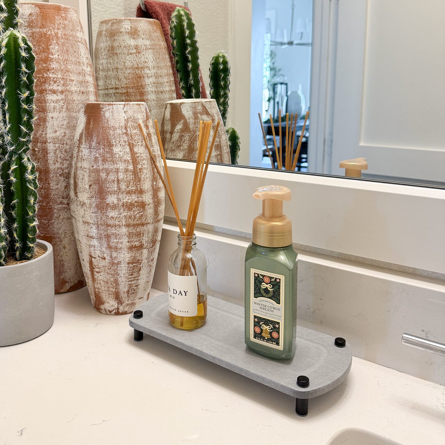 diffuser and hand soap on glacier gray sink caddy next to plant and bathroom decor