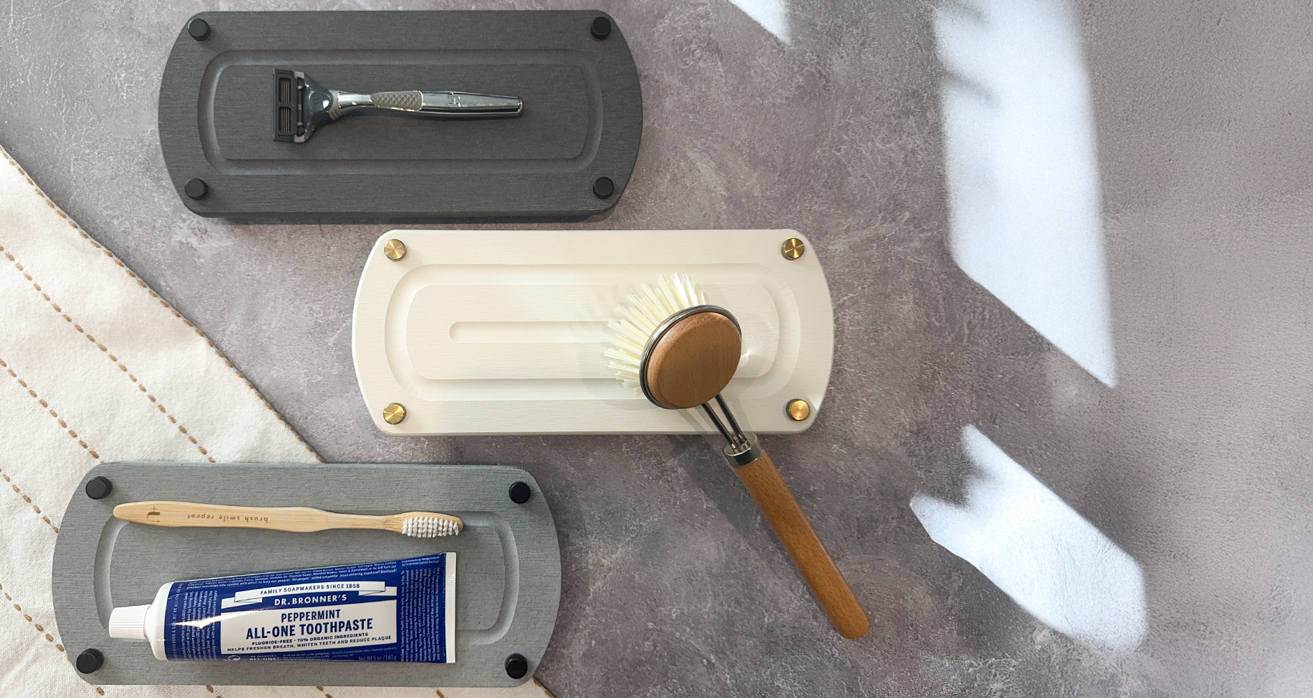 Elegant instant dry sink caddy in dark, light gray, and white, neatly holding a man’s razor, kitchen brush, toothpaste, and toothbrush—showcasing effortless organization and modern design.