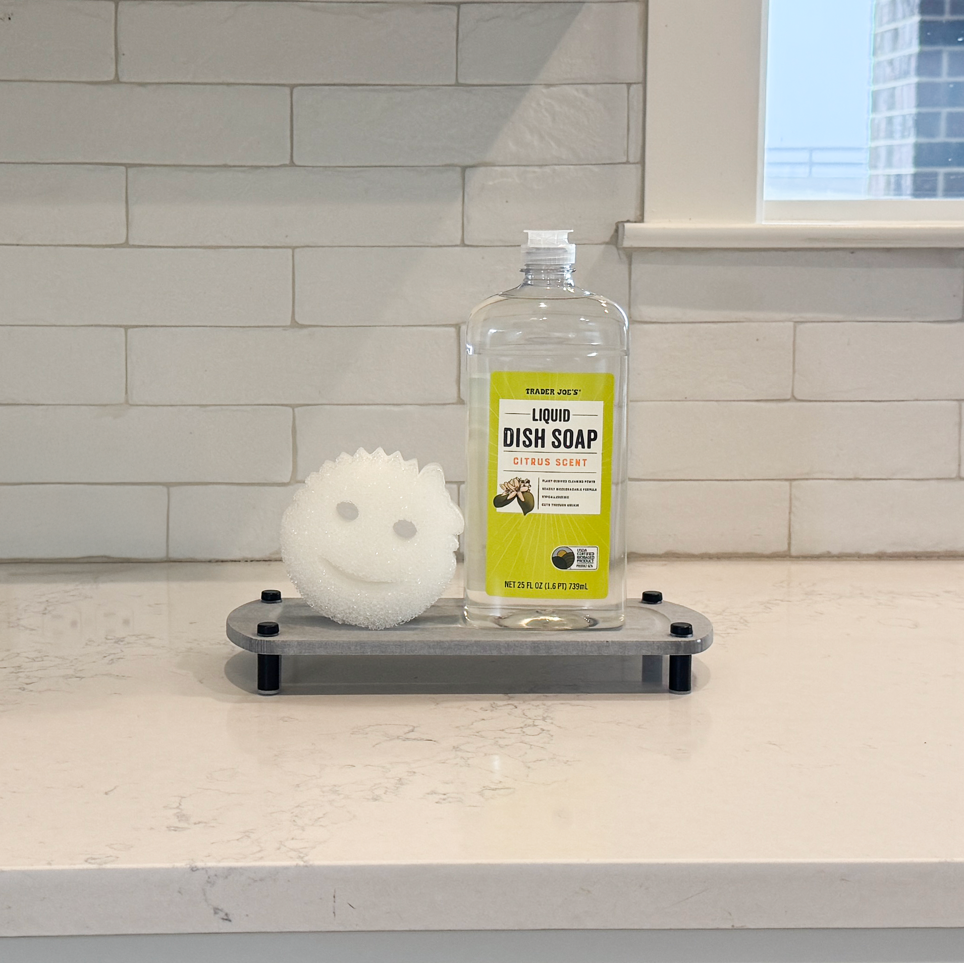 scrub daddy sponge and liquid dish soap are on the glacier gray sink caddy